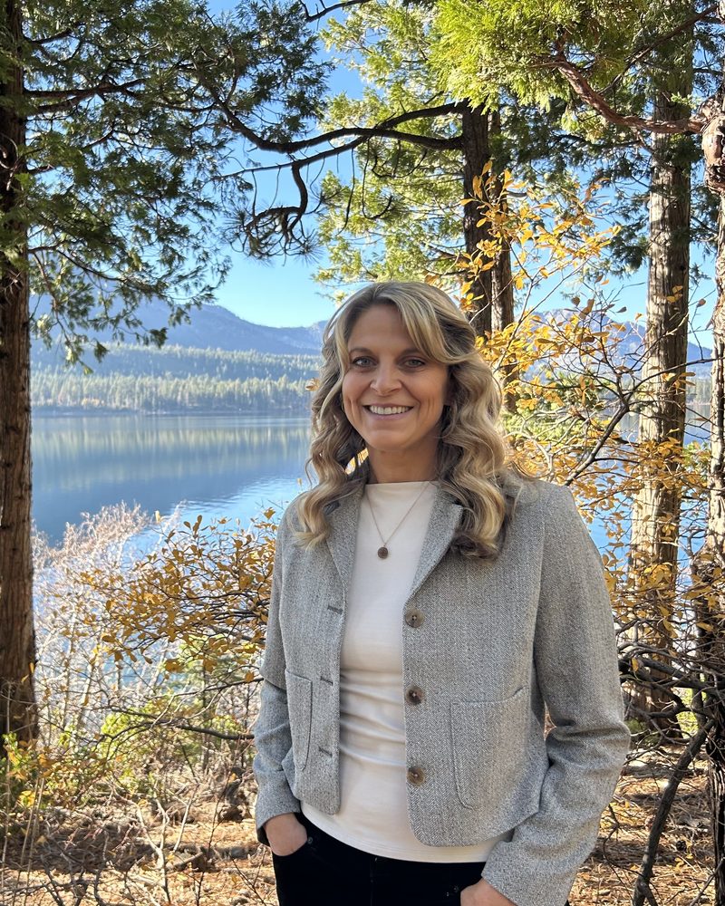 Professor Cassandra Neitling outdoors by a mountain lake