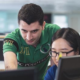 A tutor helping a student at a computer